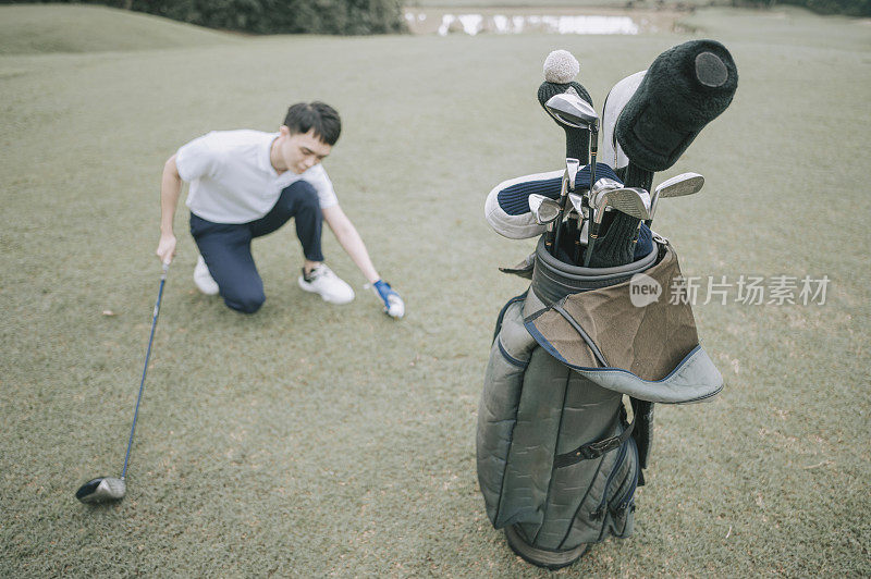 Asian chinese young couple golfer teeing off and swing his driver club on the golf course